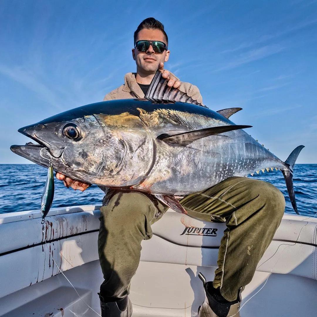 A guest holding a tuna caught on a guided charter